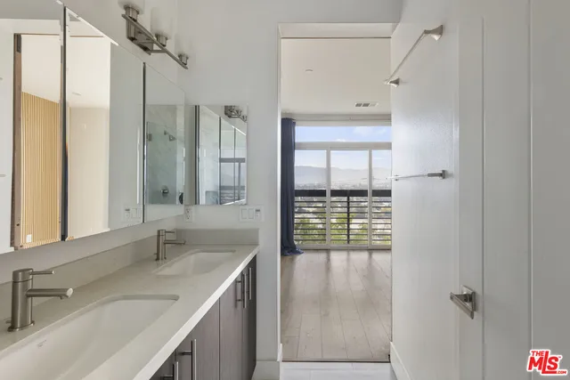 a bathroom with a double vanity sink mirror and shower