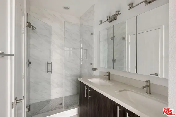 a bathroom with a granite countertop shower a sink and vanity