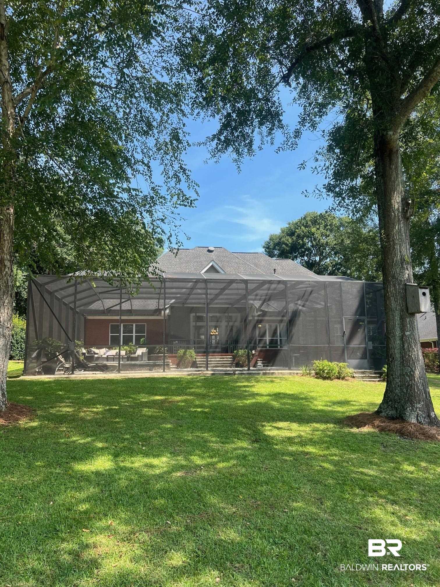 8775 Dawes Lake Road North Mobile, AL 36619 - Photo 52 of 59 Rear view of property with a lawn and a lanai
