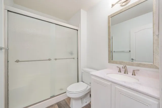 a bathroom with a granite countertop sink toilet and shower