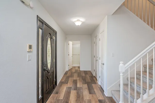a view of a hallway with wooden floor and staircase