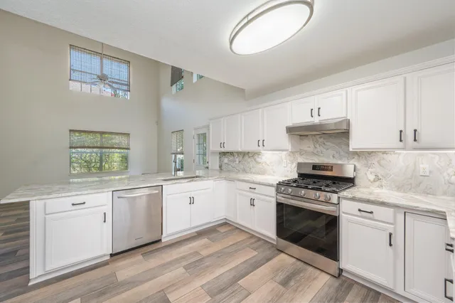 a kitchen with granite countertop cabinets stainless steel appliances and a sink