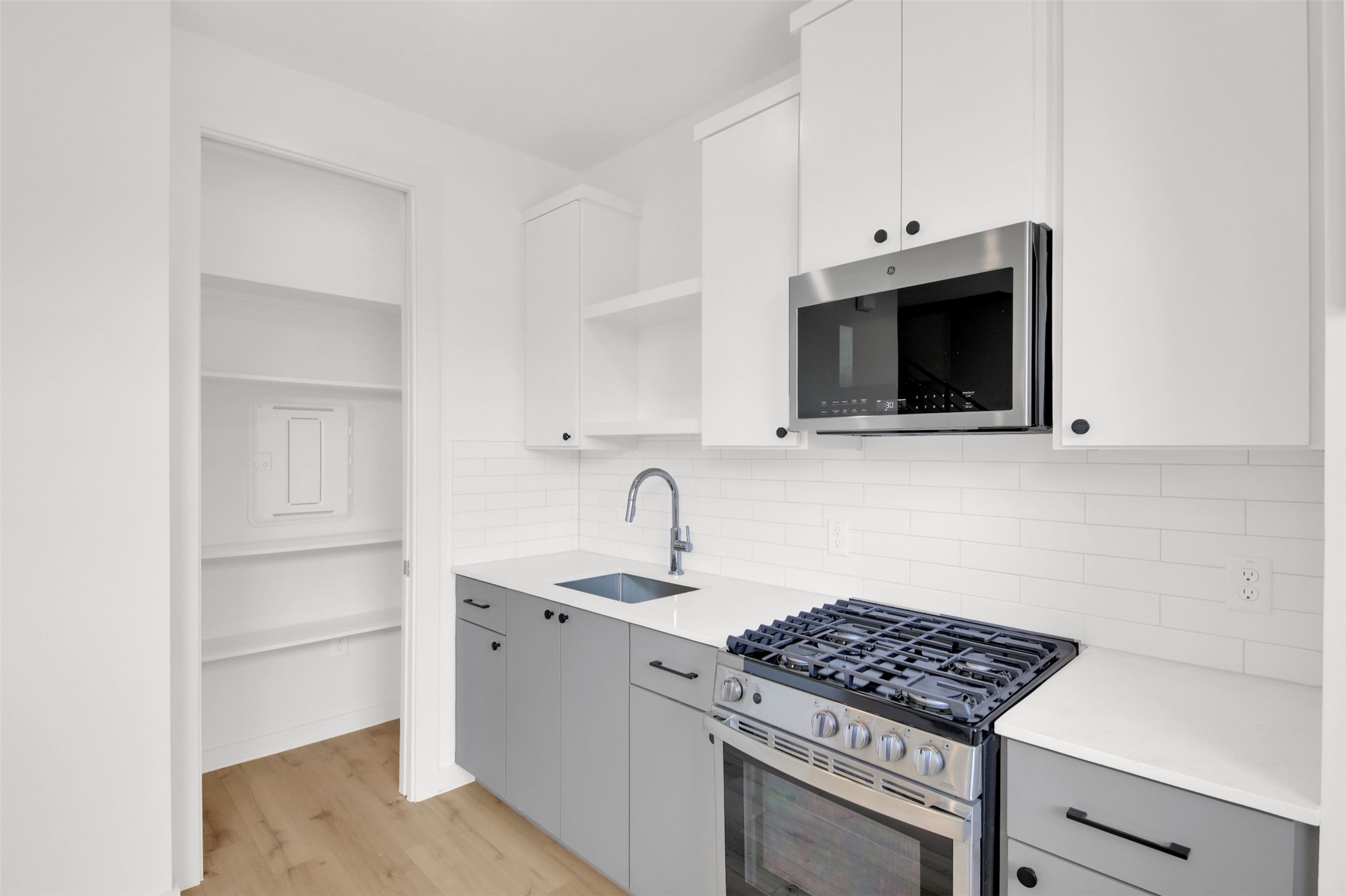 7208 Providence Avenue, Unit 2 Austin, TX 78752 - Photo 8 of 19 a kitchen with stainless steel appliances white cabinets and a stove top oven