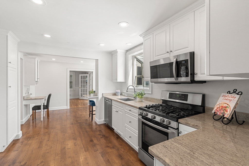 6 Shetland Road Marblehead, MA 01945 - Photo 8 of 39 a kitchen with stainless steel appliances granite countertop a stove top oven a sink dishwasher and white cabinets with wooden floor