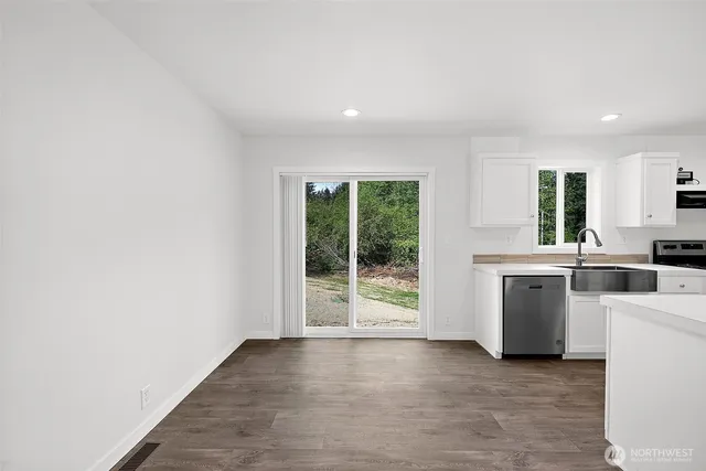a view of a kitchen with wooden floor and a sink