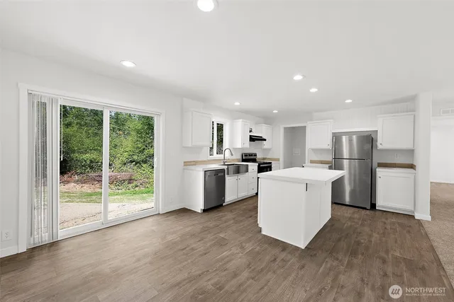 a kitchen with a refrigerator and a stove top oven