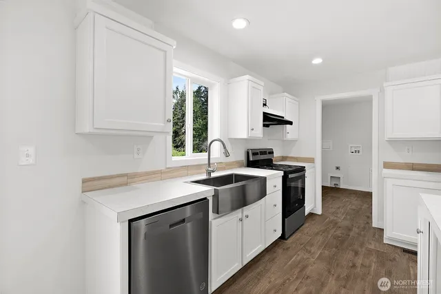 a kitchen that has a sink and a stove top oven