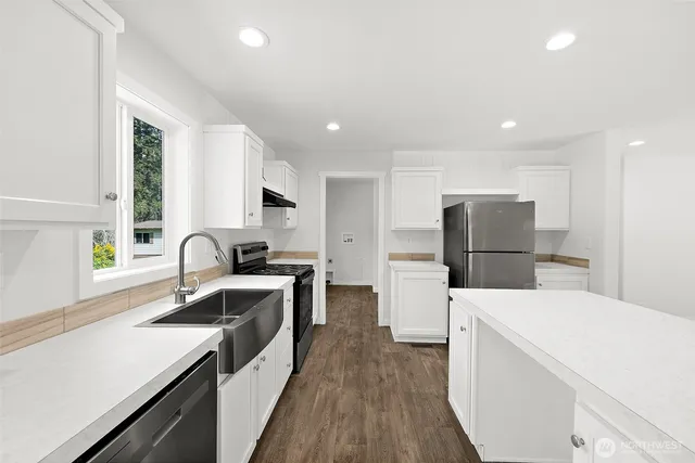 a kitchen with white cabinets and stainless steel appliances
