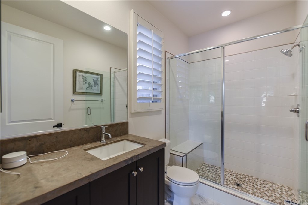 71 Sunset Cove Irvine, CA 92602 - Photo 44 of 55 a bathroom with a granite countertop sink a toilet a mirror and shower