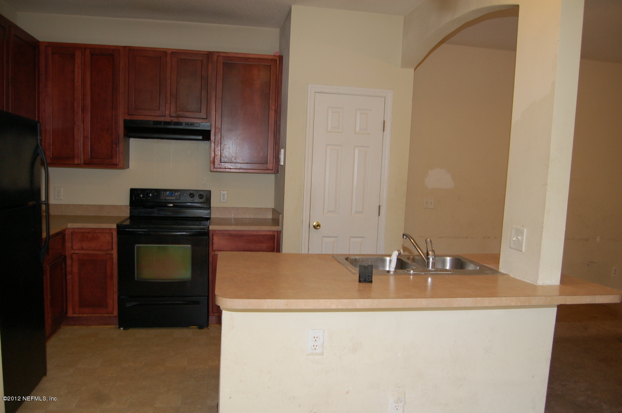 4693 Barnes Road South Jacksonville, FL 32207 - Photo 5 of 12 a kitchen with granite countertop a sink and a stove top oven