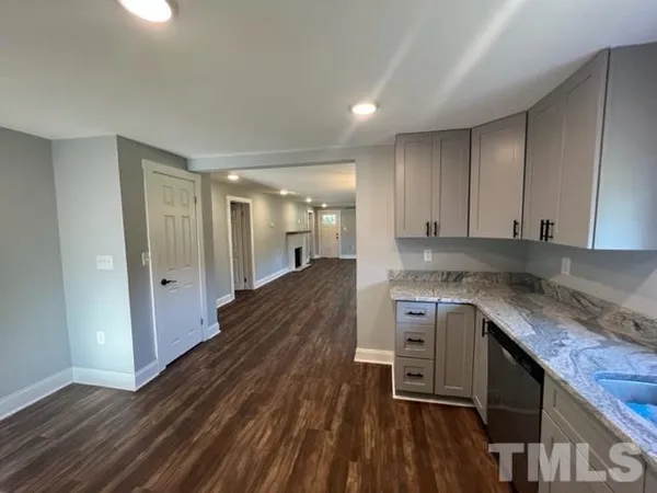 a large kitchen with granite countertop a lot of counter space and wooden floor