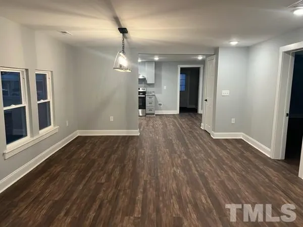 a view of a big room with wooden floor and windows