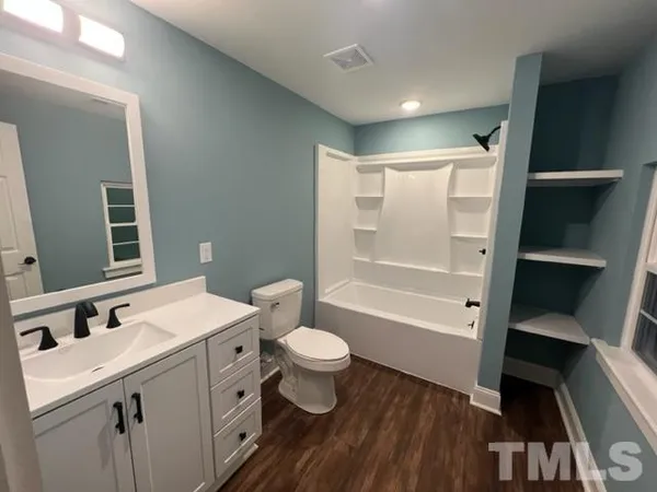 a bathroom with a sink a toilet a mirror and shower