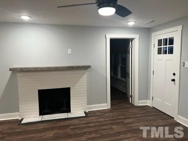 an empty room with wooden floor and fireplace