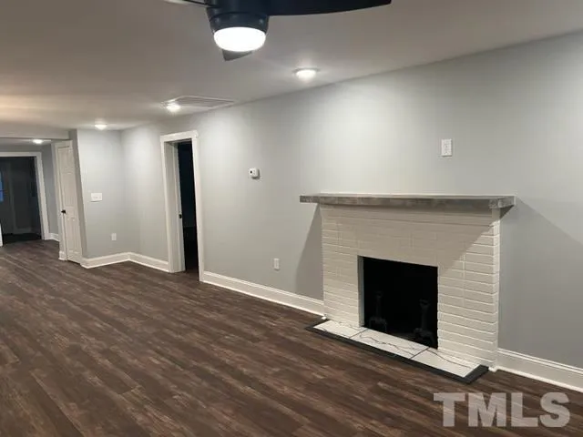 an empty room with wooden floor and fireplace