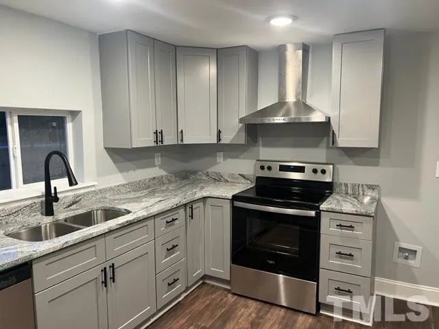 a kitchen with granite countertop a stove sink and cabinets