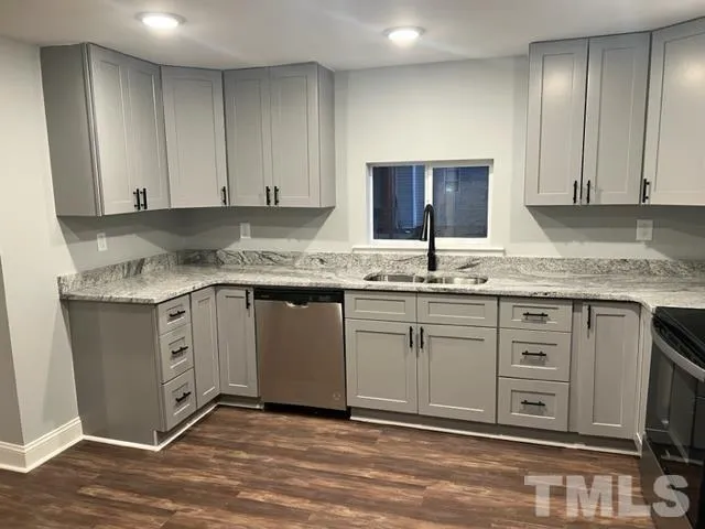a kitchen with stainless steel appliances granite countertop a sink stove and cabinets