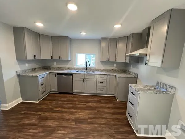 a kitchen with a sink a stove a refrigerator and cabinets