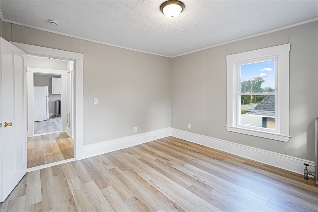 72 Main Street Pepperell, MA 01463 - Photo 10 of 26 an empty room with wooden floor and windows