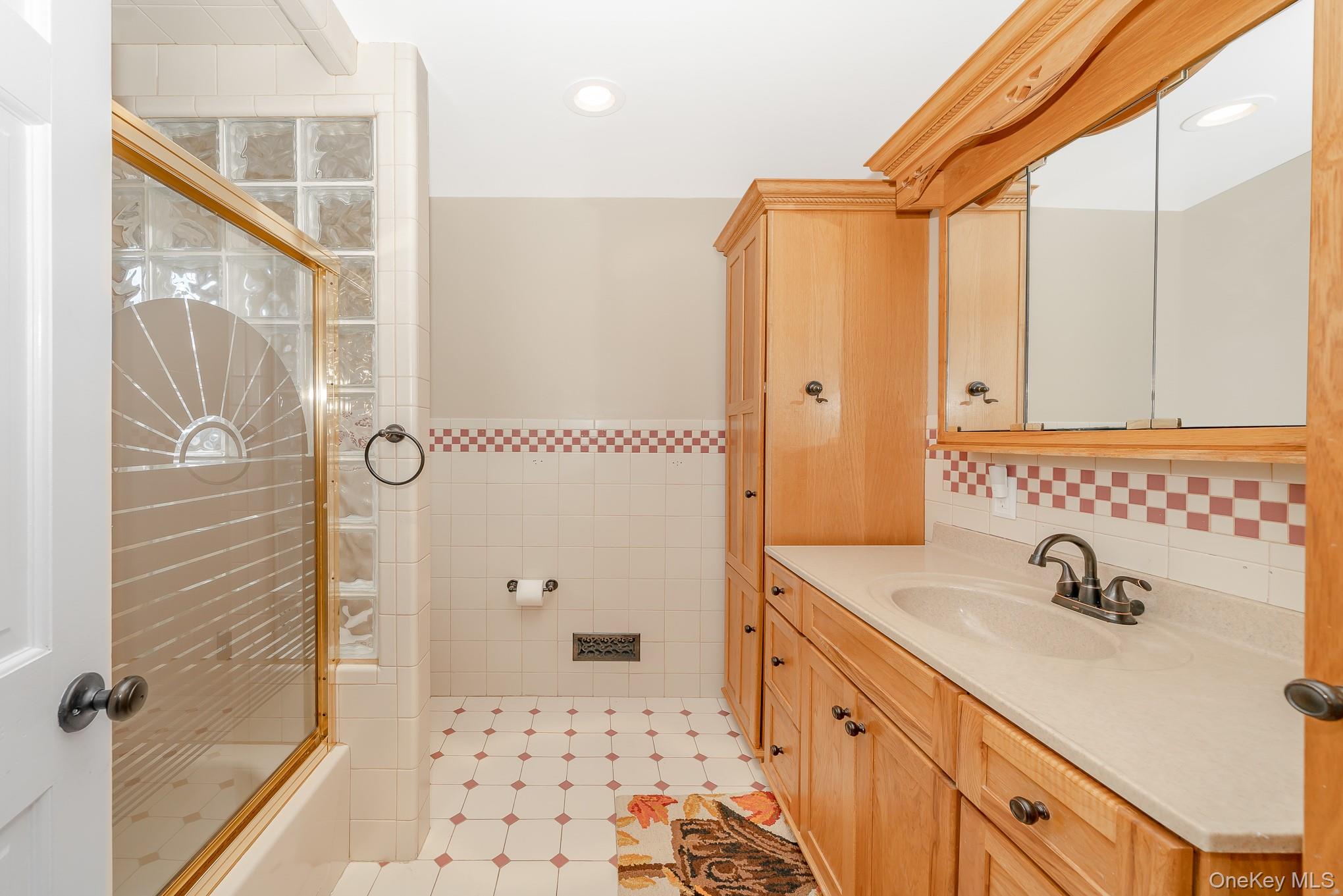 2431 Riverside Drive Wantagh, NY 11793 - Photo 11 of 23 a bathroom with a sink a mirror and a shower