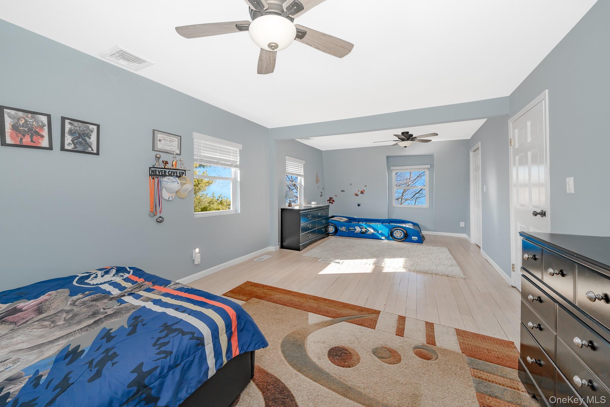 2431 Riverside Drive Wantagh, NY 11793 - Photo 21 of 23 a bedroom with a bed and a chandelier