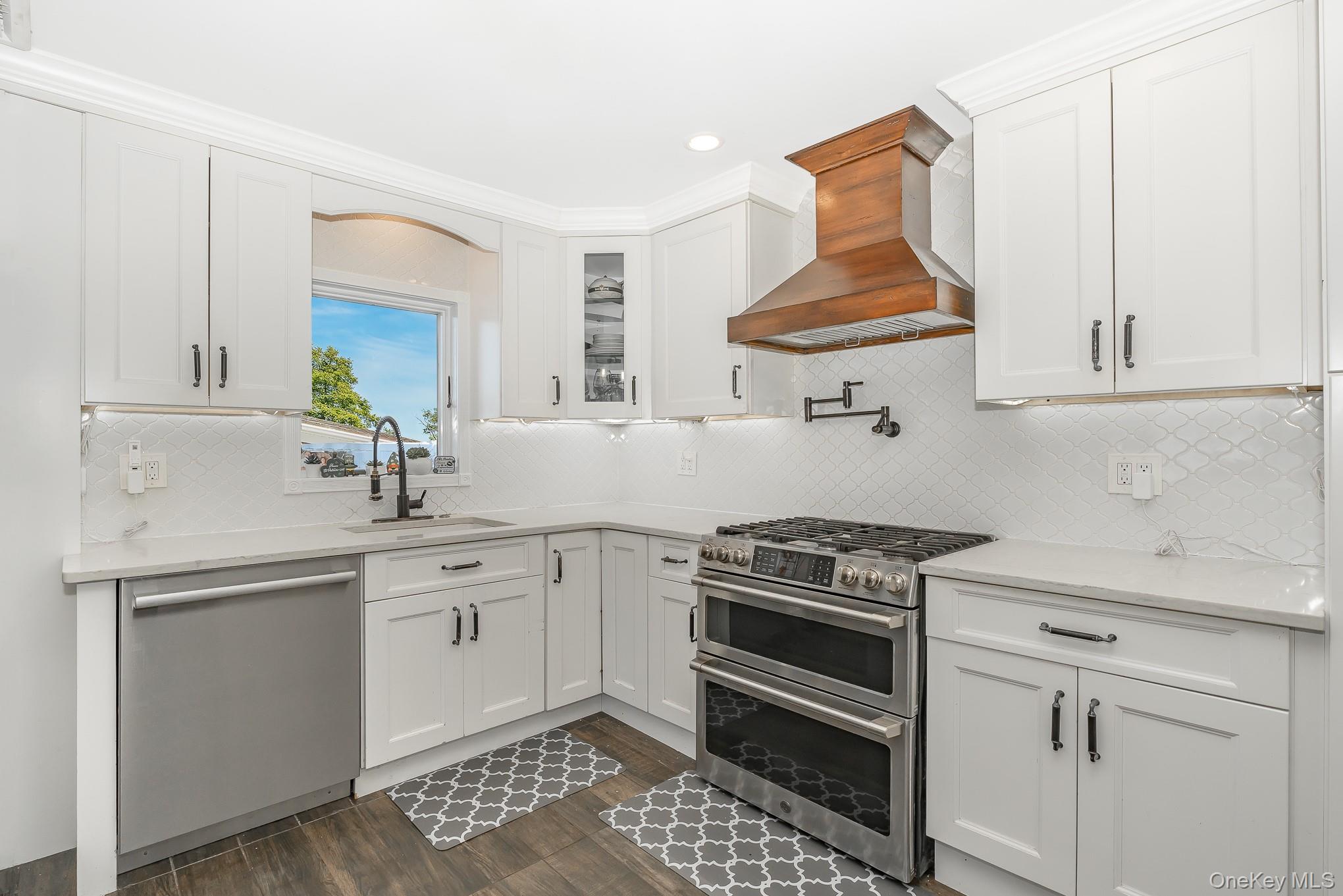 2431 Riverside Drive Wantagh, NY 11793 - Photo 23 of 23 a kitchen with stainless steel appliances a stove a sink and cabinets