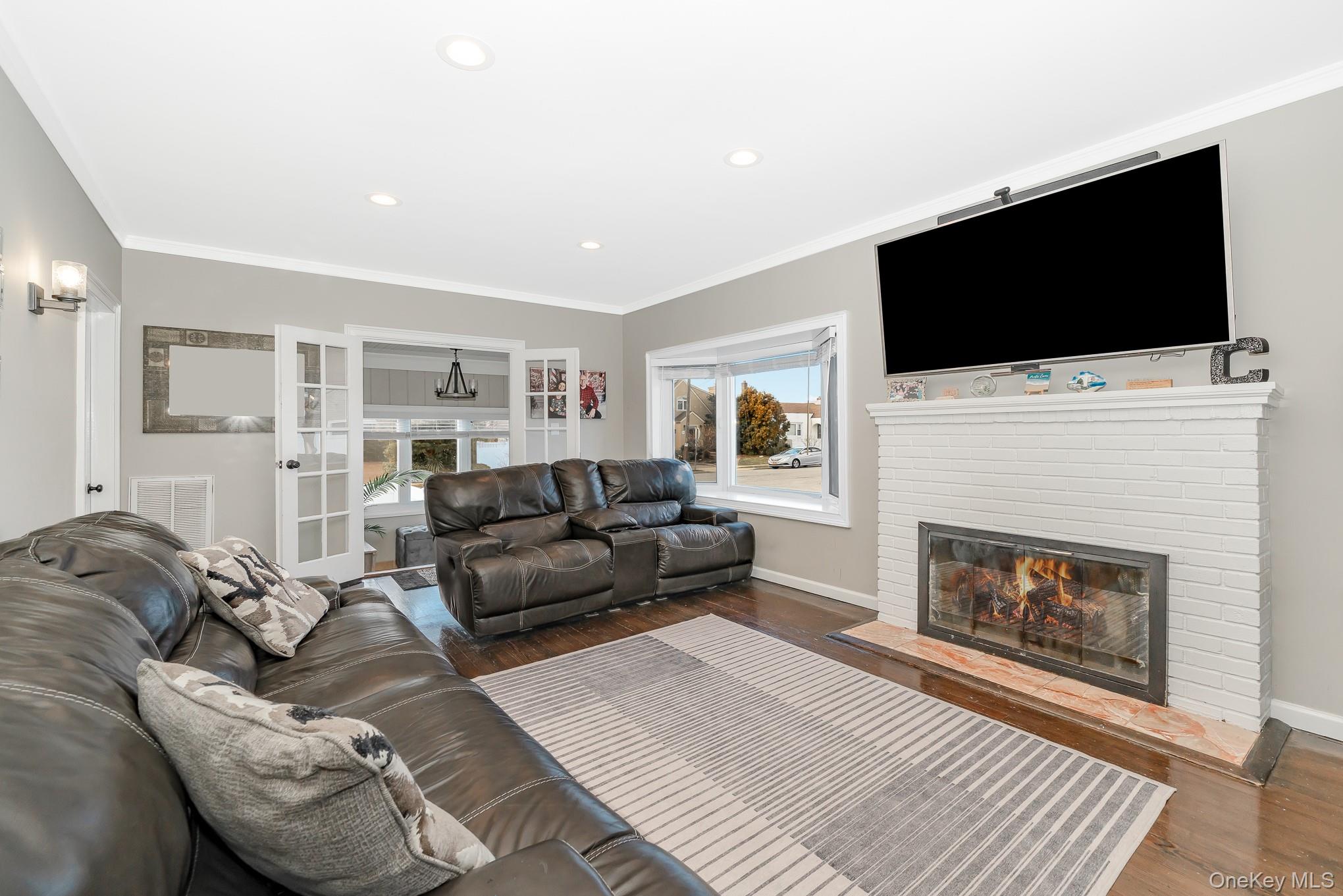 2431 Riverside Drive Wantagh, NY 11793 - Photo 7 of 23 a living room with furniture a fireplace and a flat screen tv