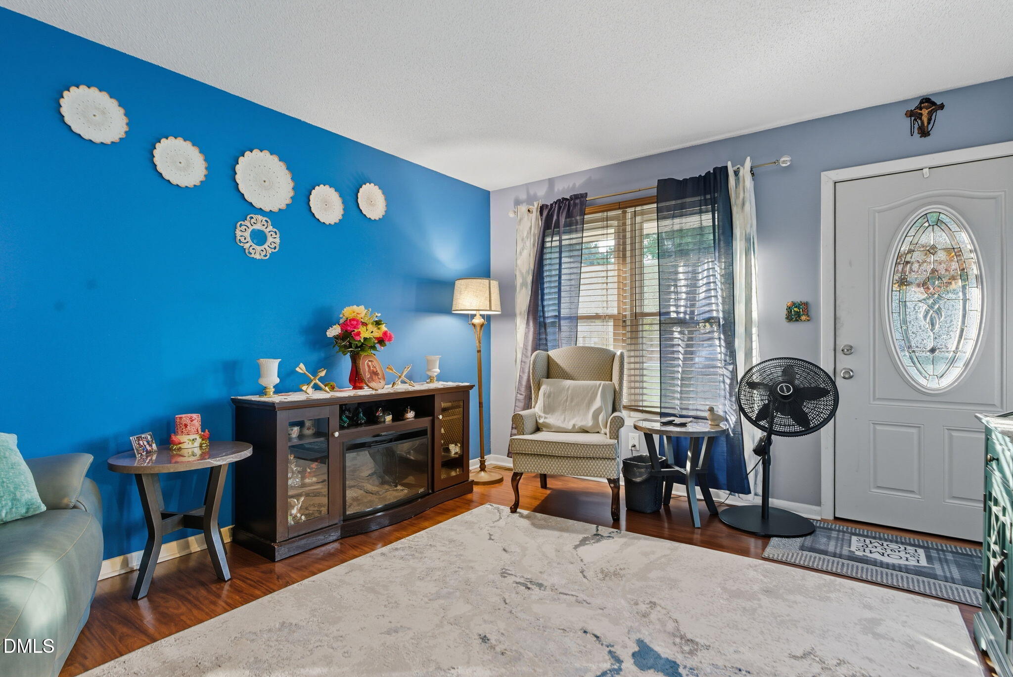 1412 Parks Village Road Zebulon, NC 27597 - Photo 7 of 40 a living room with furniture a clock on wall and a window
