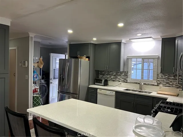 a kitchen with a sink stainless steel appliances and refrigerator