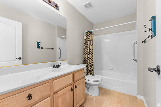 1417 Blacksmith Lane Draper, UT 84020 - Photo 37 of 57 Bathroom featuring a full vanity with wood-finish cabinetry, a single basin sink, and a large wall-mounted mirror