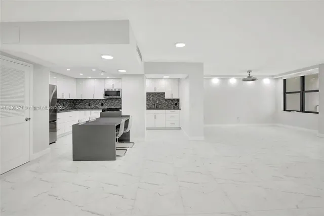 a view of kitchen with kitchen island and stainless steel appliances