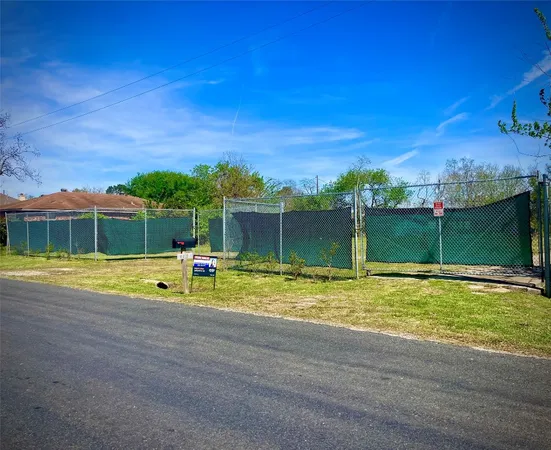 a view of a swimming pool with a yard and a large tree