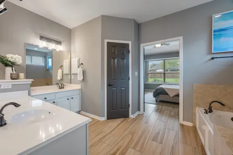 a spacious bathroom with a granite countertop sink a mirror and shower
