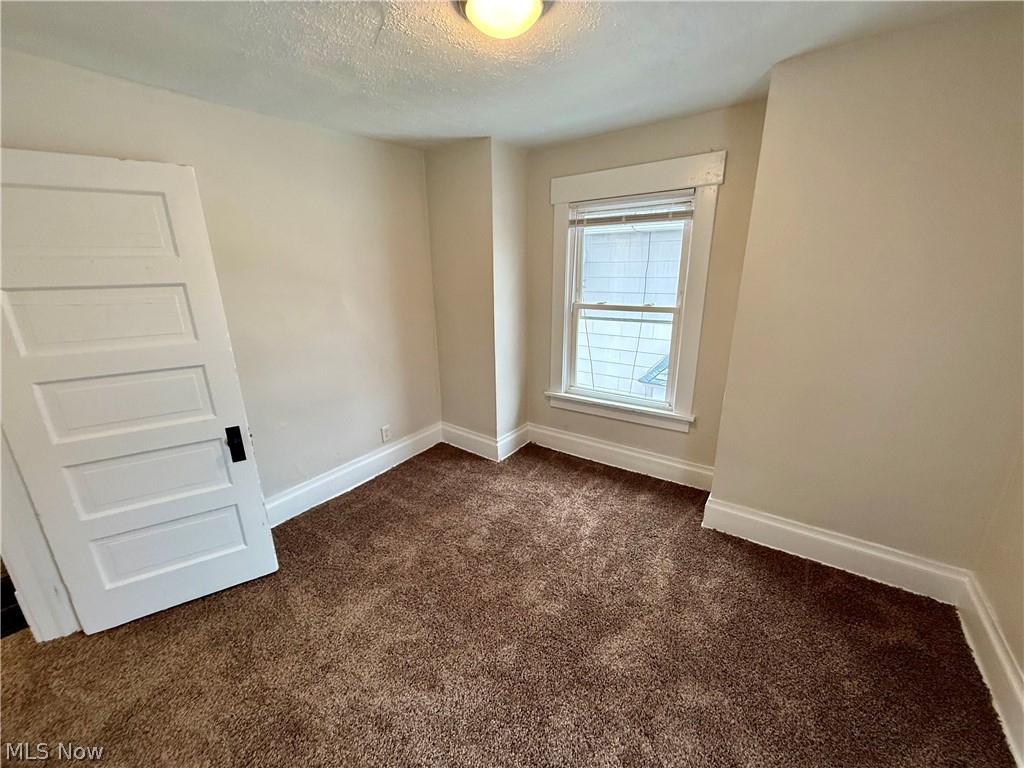 39 North Balch Street Akron, OH 44303 - Photo 13 of 19 Empty room featuring dark colored carpet and a textured ceiling