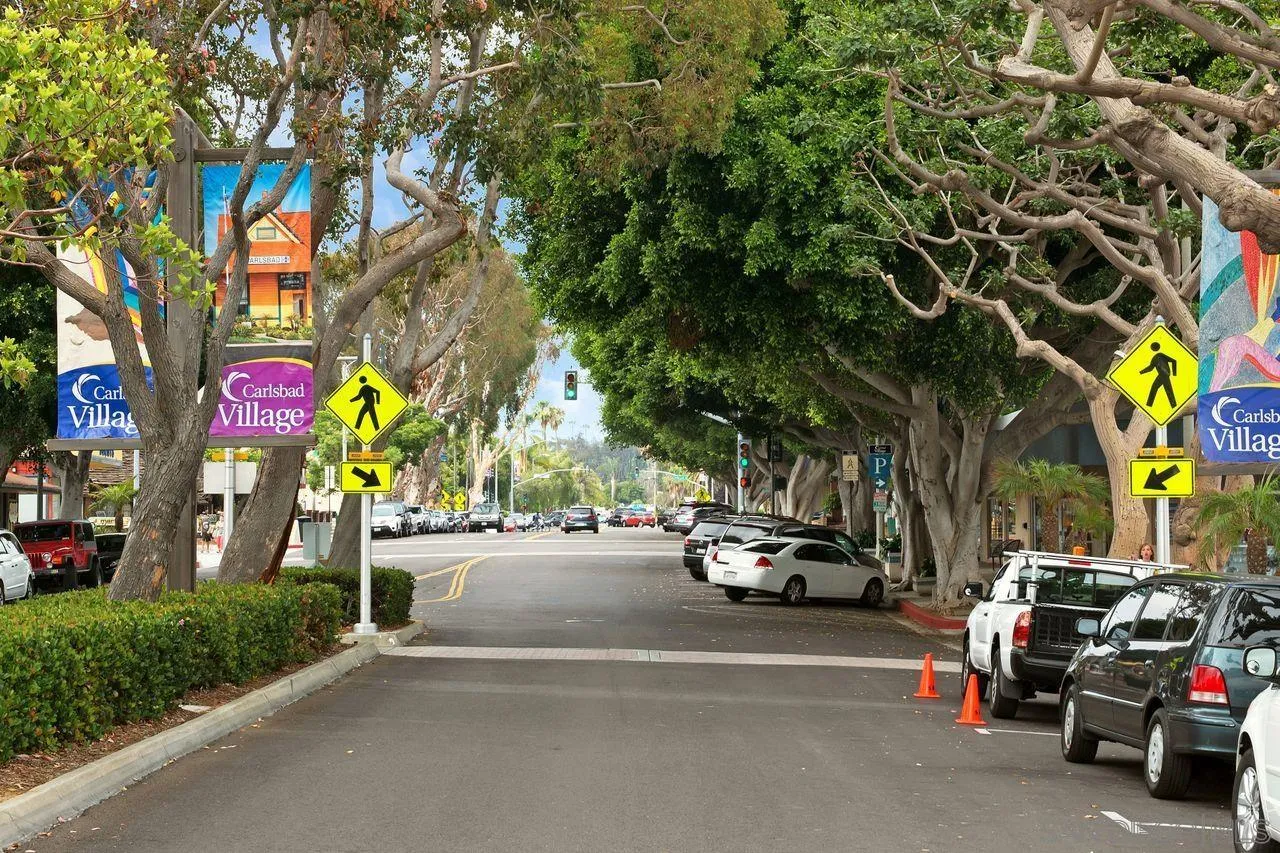 839 Mistletoe Lane Carlsbad, CA 92011 - Photo 37 of 50 a view of road with card parked on side and retail shops