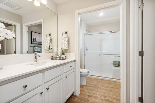 a bathroom with a sink a toilet and shower