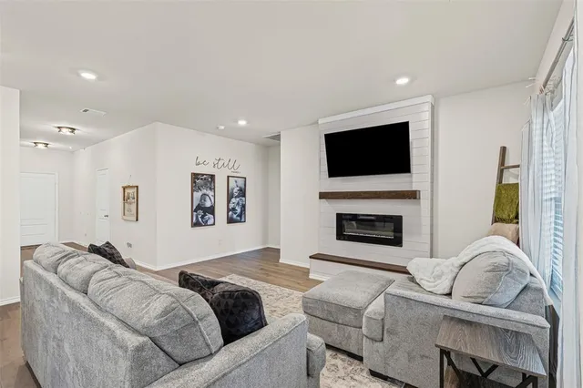 a living room with furniture a fireplace and a flat screen tv
