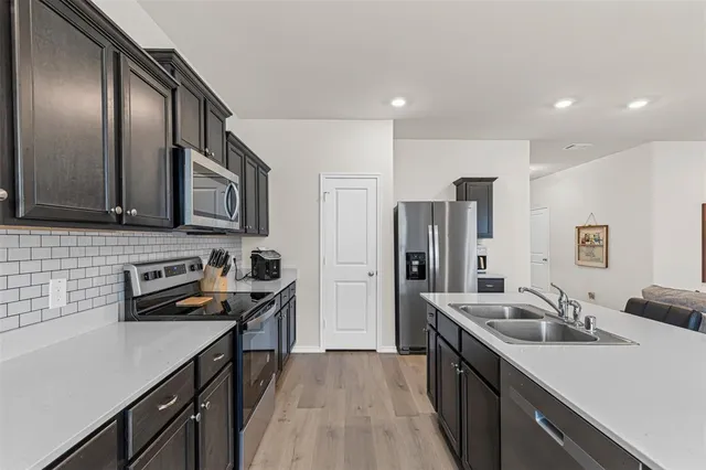 a kitchen with stainless steel appliances granite countertop a sink stove and refrigerator