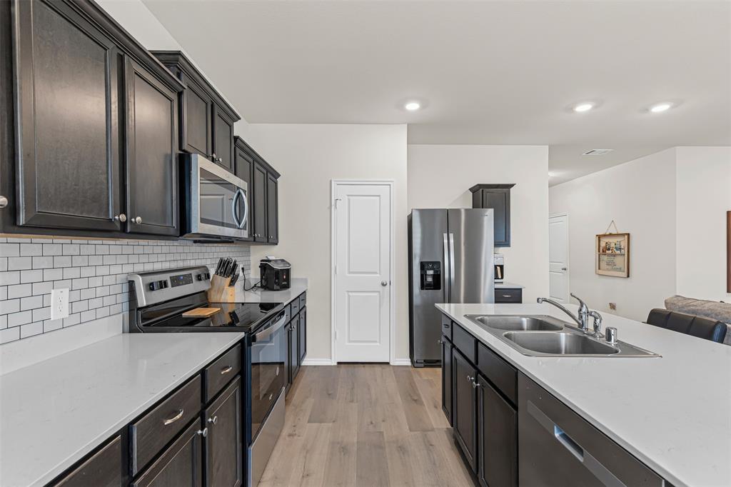 752 Amelia Court Pilot Point, TX 76258 - Photo 12 of 35 a kitchen with stainless steel appliances granite countertop a sink stove and refrigerator