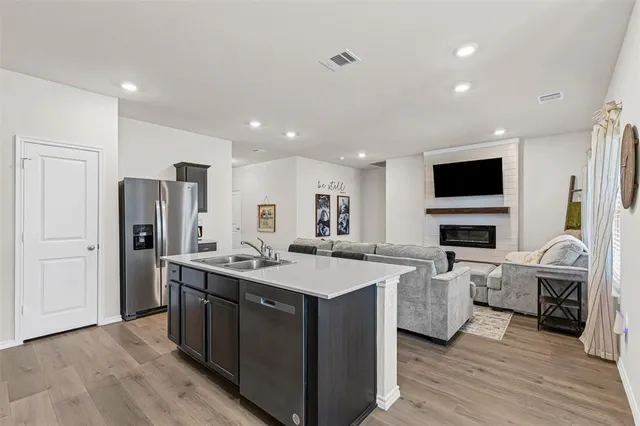 a kitchen with stainless steel appliances granite countertop a stove refrigerator and a fireplace