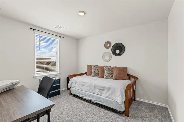 a bedroom with a bed and a lamp next to a window