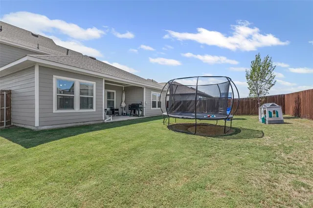 a view of a house with a backyard and a patio