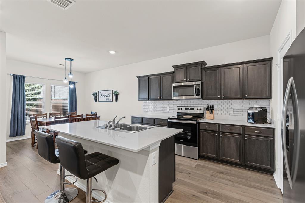 752 Amelia Court Pilot Point, TX 76258 - Photo 10 of 35 a kitchen with stainless steel appliances granite countertop a sink stove and refrigerator