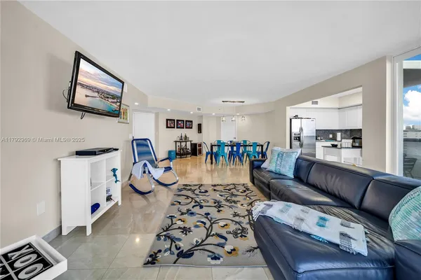 a living room with furniture and view of kitchen