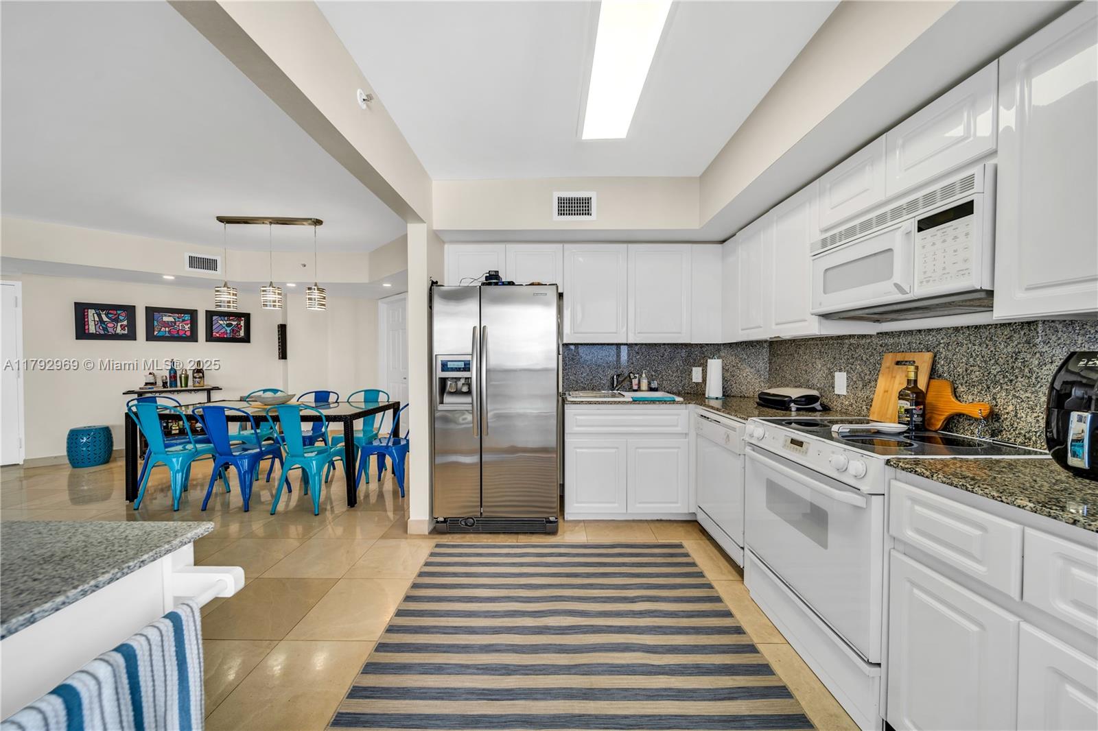 6301 Collins Avenue, Unit 1708 Miami Beach, FL 33141 - Photo 28 of 43 a kitchen with stainless steel appliances granite countertop a refrigerator and a stove top oven