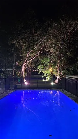 a view of a patio with a table and chairs under an umbrella with a barbeque grill