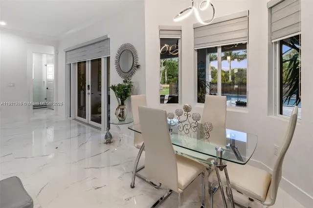 a living room with furniture a large window and glass door