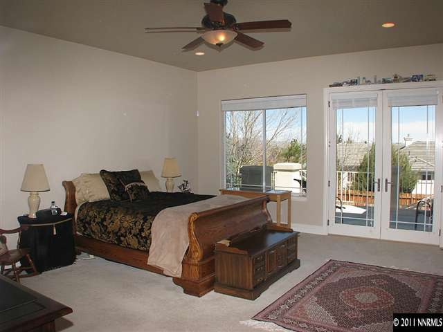 135 Gazelle Road Reno, NV 89511 - Photo 9 of 13 a spacious bedroom with a bed a couch and large window