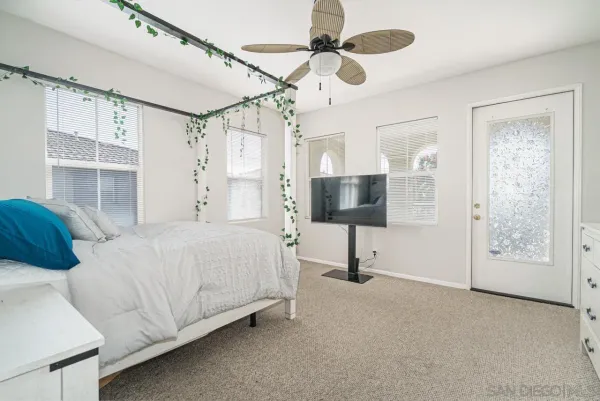 a spacious bedroom with a bed and a flat screen tv