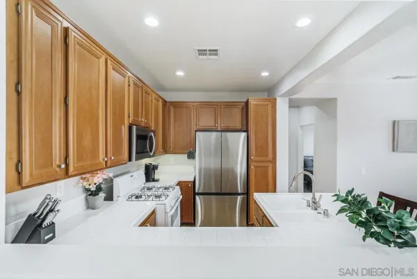 a kitchen with stainless steel appliances granite countertop a refrigerator and a sink